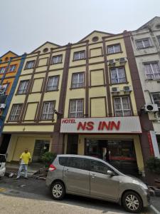 马六甲NS INN Hotel的停在大楼前的货车