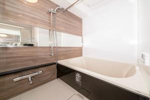 东京Creazione Akasaka的浴室配有大型白色浴缸和水槽