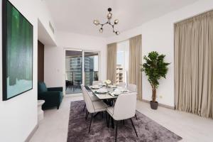 阿布扎比Maison Privee - Elegant & Panoramic Sea View Apt on Al Reem Island的一间带桌子和白色椅子的用餐室