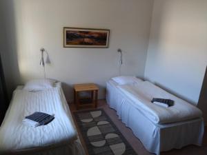 本茨福什Hotell Hemgården的一间设有两张床和一张桌子的房间