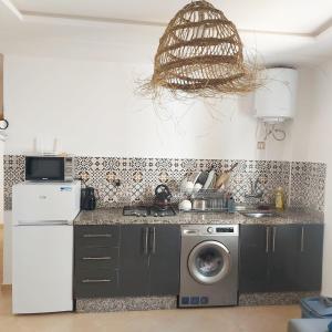 塔哈佐特La Brise Studio à Taghazout 2-3px的厨房配有洗衣机和微波炉。