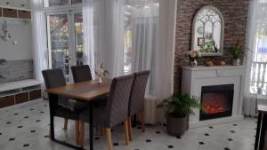 巴尔奇克维多利亚家庭酒店的一间带桌子和壁炉的用餐室