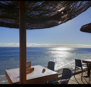 坎德拉里亚THE HAPPINESS PENTHOUSE Dream Holiday at 100m Beach!的桌椅享有海景。