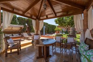 莫特里尔Villa Torres Motril的户外庭院设有木制凉亭,配有桌椅