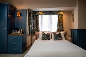 格拉茨克洛斯Ethorpe Hotel by Chef & Brewer Collection的一间卧室配有一张带蓝色橱柜的床和窗户。