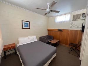 WinkieGlossop Motel的一间卧室设有一张床、一个窗口和风扇