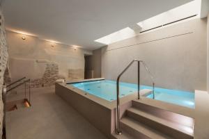 托莱多Áurea Toledo by Eurostars Hotel company的一间带楼梯的浴室内的热水浴池