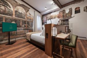 托莱多Áurea Toledo by Eurostars Hotel company的配有一张床和一张书桌的酒店客房