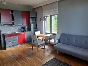拉普阿辛普森库拉斯公寓式酒店的厨房配有沙发和桌椅