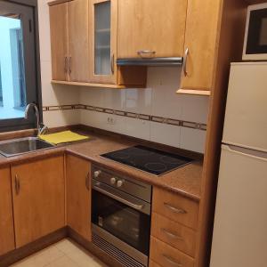 戈梅拉岛圣塞瓦斯蒂安JS crecer的厨房配有木制橱柜、炉灶和水槽。