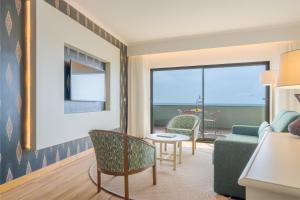丰沙尔Pestana Vila Lido Madeira Ocean Hotel的客厅配有沙发和桌椅