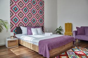 阿尔巴尤利亚CONFORT HOUSE PLUS的一间卧室配有一张带紫色毯子的床