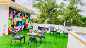 加尔各答Olive Serviced Apartments Salt Lake Kolkata的庭院设有桌椅和色彩缤纷的墙壁。