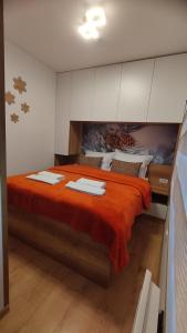 亚霍里纳Vila Jahor Apartmani Dis 7 i 8的一间卧室配有一张带橙色床单的大床
