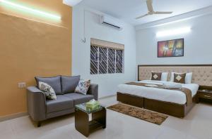 加尔各答Olive Serviced Apartments Salt Lake Kolkata的一间卧室配有一张床和一张沙发