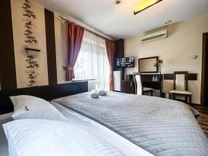 热舒夫梅什科酒店的一间卧室配有一张大床和两条毛巾