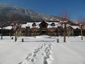 圣马梅特Village Club Les Balcons des Pyrénées的雪地覆盖的建筑,雪地里留下了脚印
