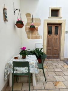 科佩尔蒂诺Nido d'amore in Salento的桌子和两把椅子以及桌子和门