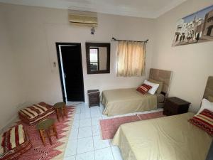 马拉喀什Riad Nour Travel-Les Riads Nour Resorts的一间卧室配有两张床和一张桌子及椅子