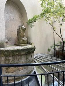 巴黎Hôtel Prince de Conti的狮子雕像坐在墙上