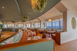 丰沙尔Pestana Vila Lido Madeira Ocean Hotel的餐厅设有桌椅和窗户。