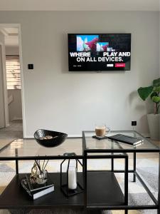 伦敦Stunning Newly Decorated Flat with Private Entrance的客厅配有桌子和墙上的电视