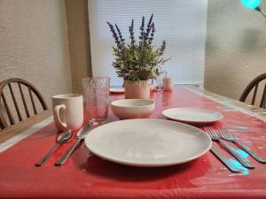 尼亚加拉瀑布Urban Getaway on 7th的红色桌布上带盘子和餐具的桌子