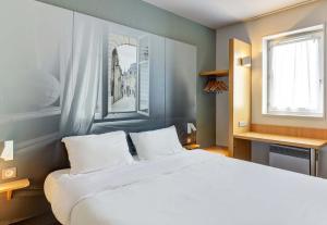 第戎B&B HOTEL Dijon Les Portes du Sud的卧室设有一张白色大床和一扇窗户。