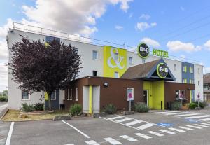 第戎B&B HOTEL Dijon Les Portes du Sud的前面有一个停车位的酒店