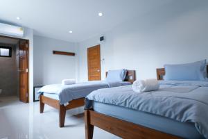 Ban Chamun (2)ChomTique Hotel的一间卧室配有两张蓝色床单