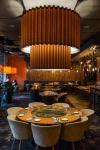 塔尔图V温泉会议酒店的餐厅设有桌椅和大吊灯。