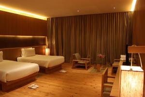 帕罗Udumwara Resort的酒店客房设有两张床和起居区。