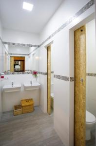 桑蒂蓬塞Italica Hostel的一间带两个盥洗盆和卫生间的浴室