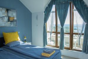 瓦尔纳Black sea Narcissus - quiet studio with amazing sea view的蓝色的卧室设有床和大窗户
