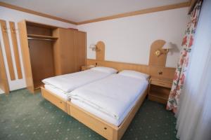 萨斯阿尔马格尔Hotel Alpenhof的一间卧室配有白色床单