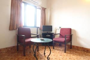 维沙卡帕特南Agarwal's Residency的一间设有两把椅子、一张桌子和一台电视的房间