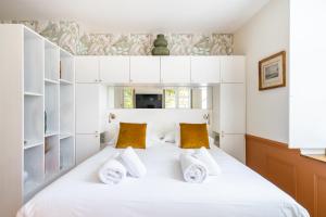 普罗旺斯地区萨隆La Réserve de Salon de Provence的一间卧室配有一张带白色橱柜和黄色枕头的床。