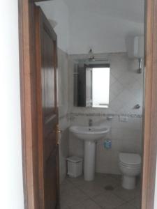 波利卡Agriturismo La Mancosa的一间带水槽和卫生间的浴室以及窗户。