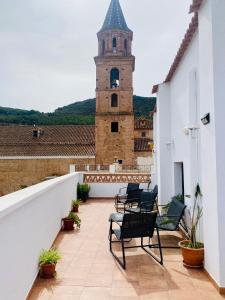 丰东Apartamentos rurales, La Casa de Baltasar的一个带椅子和钟楼的阳台