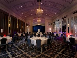 温莎Castle Hotel Windsor的一个带桌椅和吊灯的宴会厅