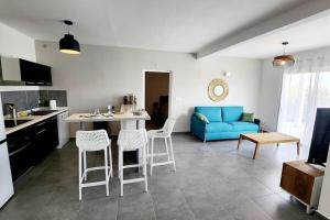 圣马丁岛Friar's beach - Luxurious unit by the beach的厨房以及带蓝色沙发的起居室。