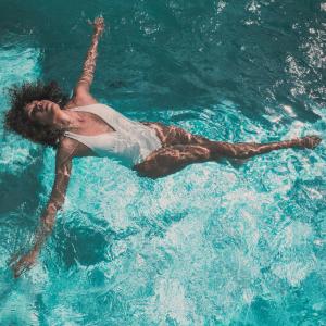 卡萨莱马里蒂莫OKU - soulful suites的一个人在蓝色的水中游泳
