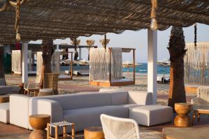 乌姆赛义德Ramlah Resort Qatar的海滩上的客厅配有沙发和椅子
