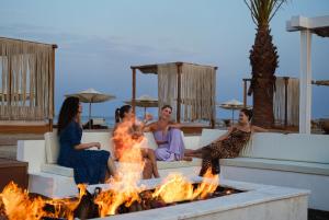 乌姆赛义德Ramlah Resort Qatar的一群坐在火坑周围的妇女