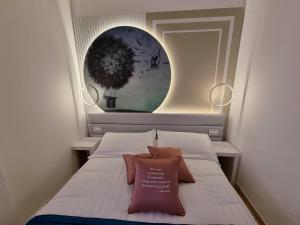 里米尼安格里尼酒店的小卧室配有带枕头的床