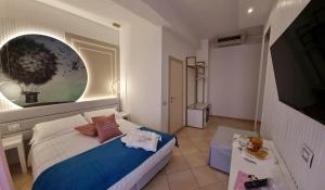 里米尼安格里尼酒店的一间小卧室,配有一张床和电视