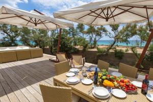 托雷拉皮罗Villa Bianca by Perle di Puglia的海景甲板上的木桌和食物