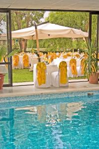 安卡拉贝斯特公寓酒店的一张桌子、黄色的椅子和一个游泳池
