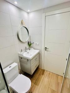 巴利亚多利德Loft de estilo industrial con garaje的白色的浴室设有水槽和镜子