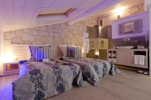 塞尔丘克塞拉艾弗斯酒店&SPA的一间卧室设有两张床和石墙